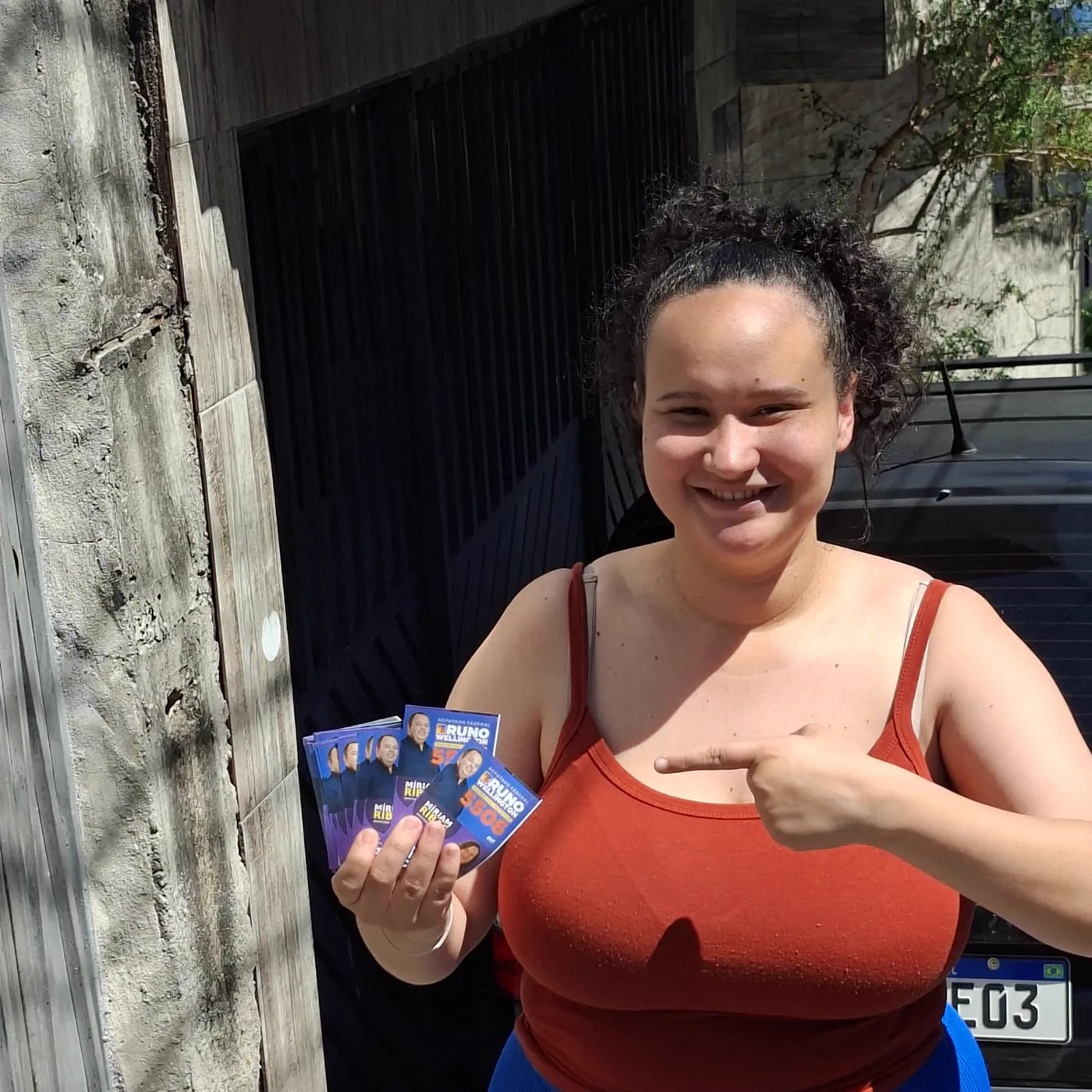 Apoiadora aponta para o material da campanha