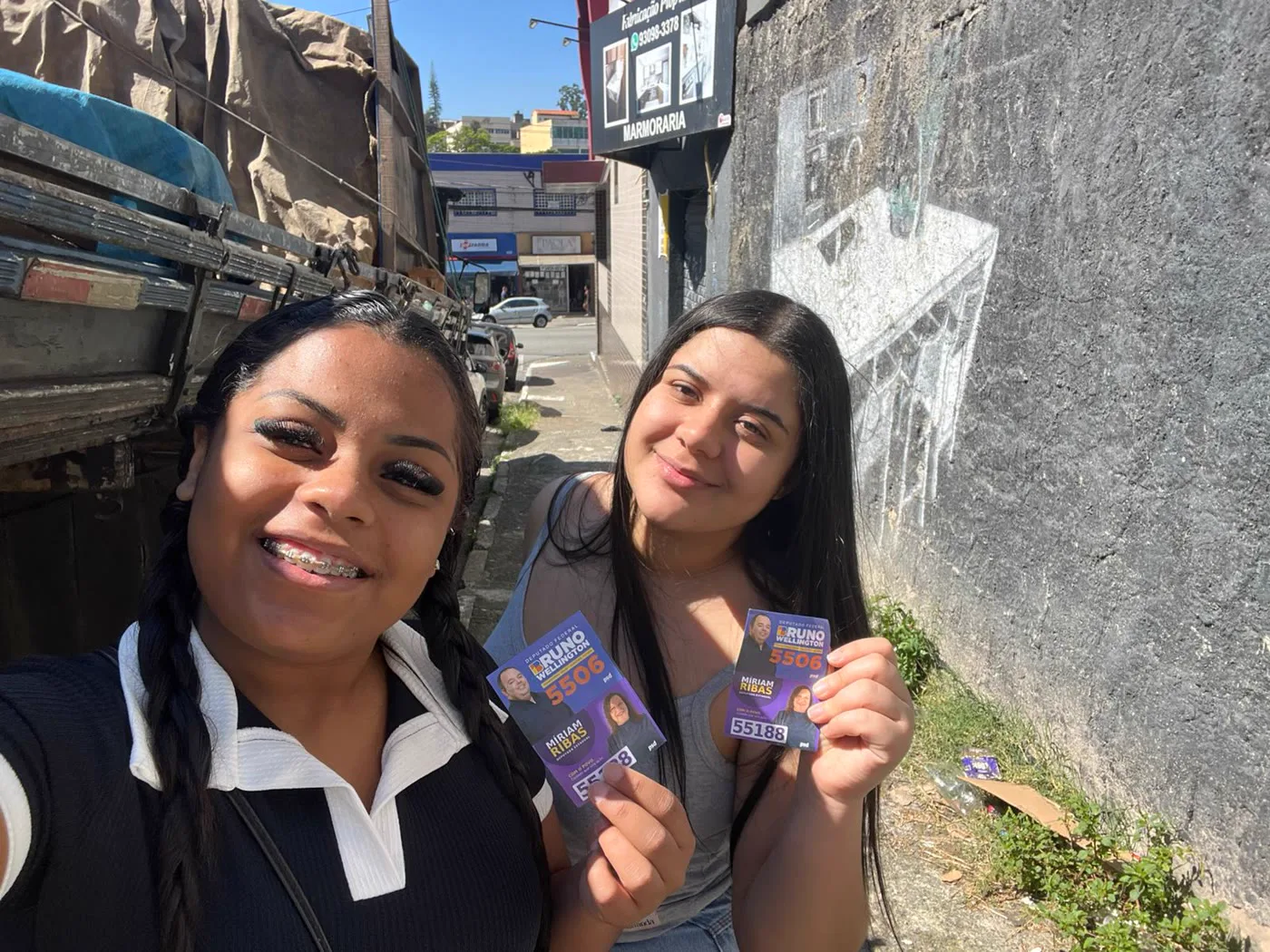Duas apoiadoras sorrindo com o material da campanha